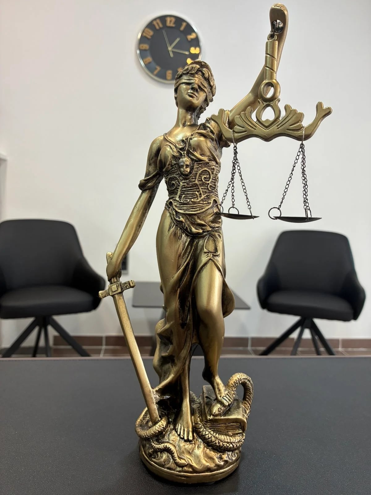 Фигура богиње правде са вагом на радном столу
